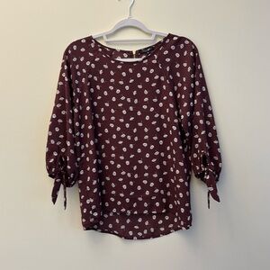 Maroon blouse with white flowers.  Zipper on back. Size S. Never worn!